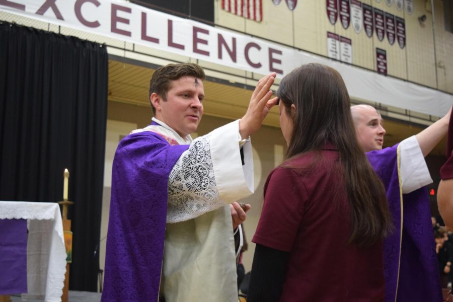 Father Flood applies ashes to a student during Ash Wednesday Mass.