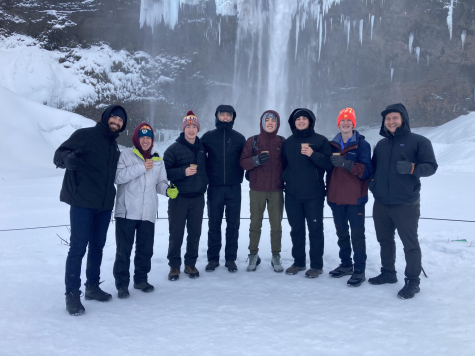 The group of Dowling travelers pose in front of a waterfall in Iceland.