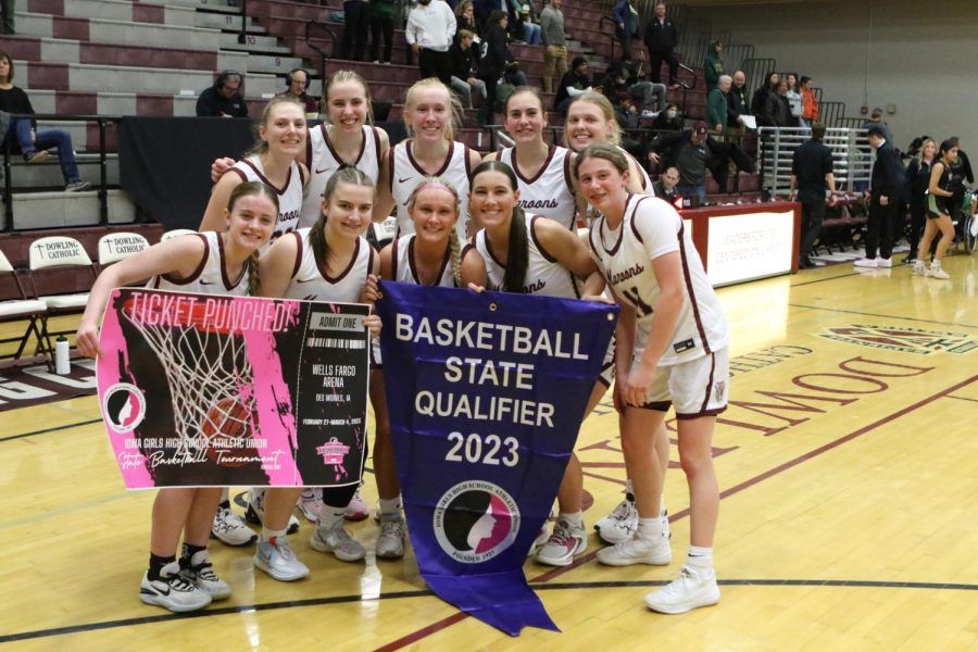 Dowling Catholic Girls Basketball team holds the state banner after a 59-37 win in the sub-state game. 
[E. Hulst]