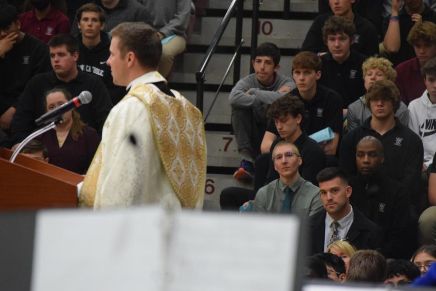 Father Reed Flood speaks while the sophomore boys listen intently.