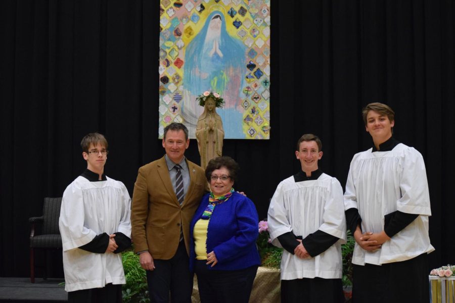 Luke Howard, Dr. Dan Ryan, Paula Plasencia, Matthew Dietrich, and Isaiah Seymour smile at the camera in front of the Mary statue.