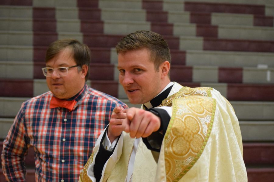 Father Reed Flood points at the camera after Dowlings first-ever, school-wide May Crowning.