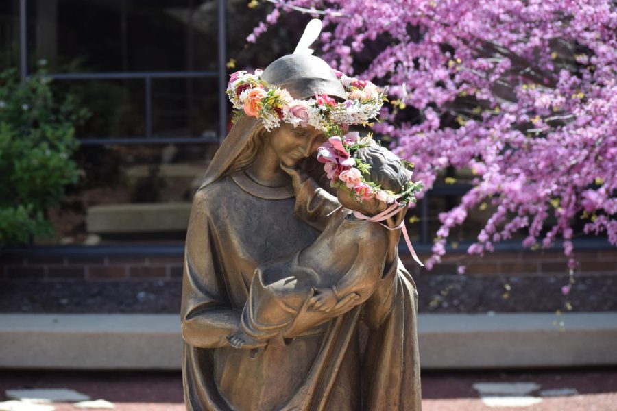 The Mary and Jesus statue in the courtyard with crowns of flowers.