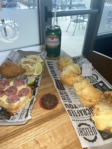 A spread of the delicious food at Terra Cafe includes brigadeiros docinhos, sausage and cheese sfihas, coxinhas, guaraná, and pao de quiejo. (Ella Johnson)