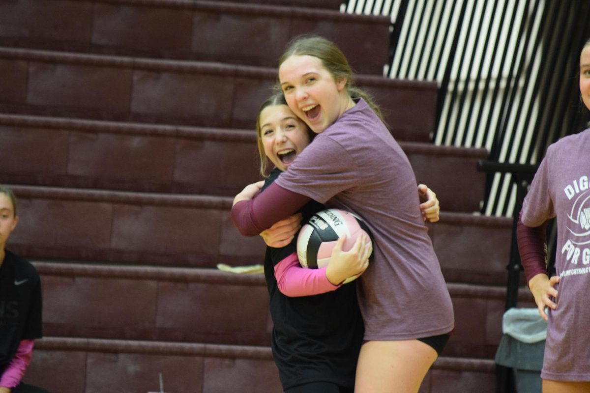 Alexis Theis and Bella Simons hug before their games.
