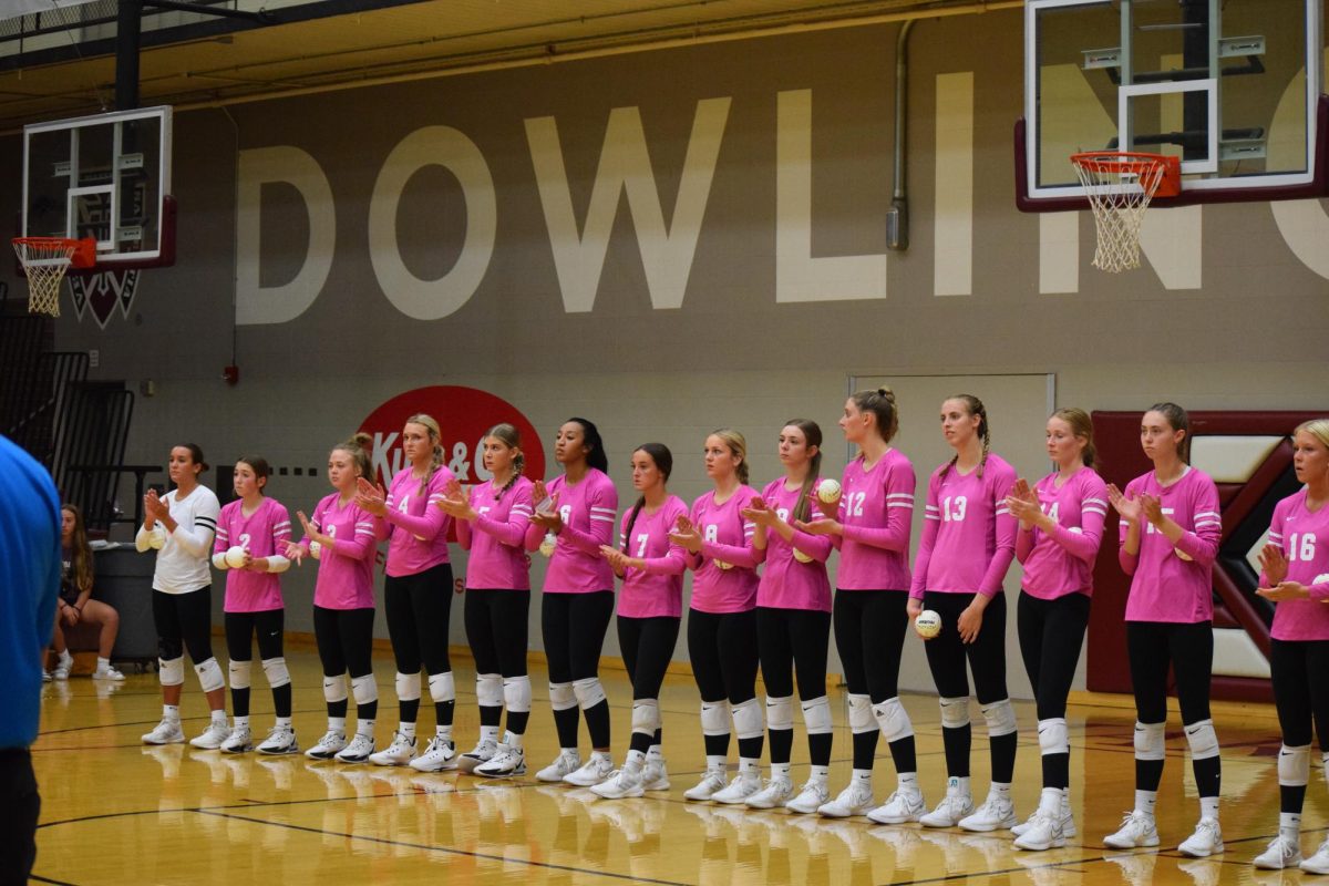 The Dowling Catholic Volleyball team stands, being introduced before the match.