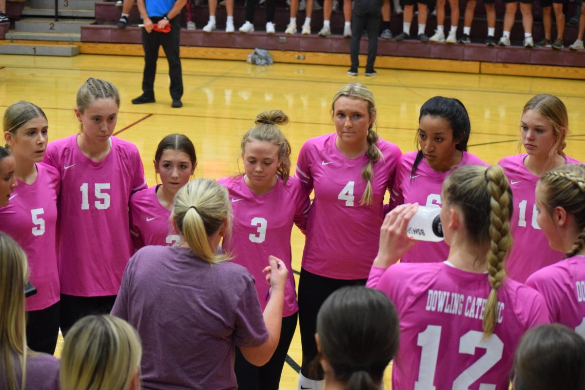 The volleyball team listens to Coach Mary Beth Wiskus after the first set.