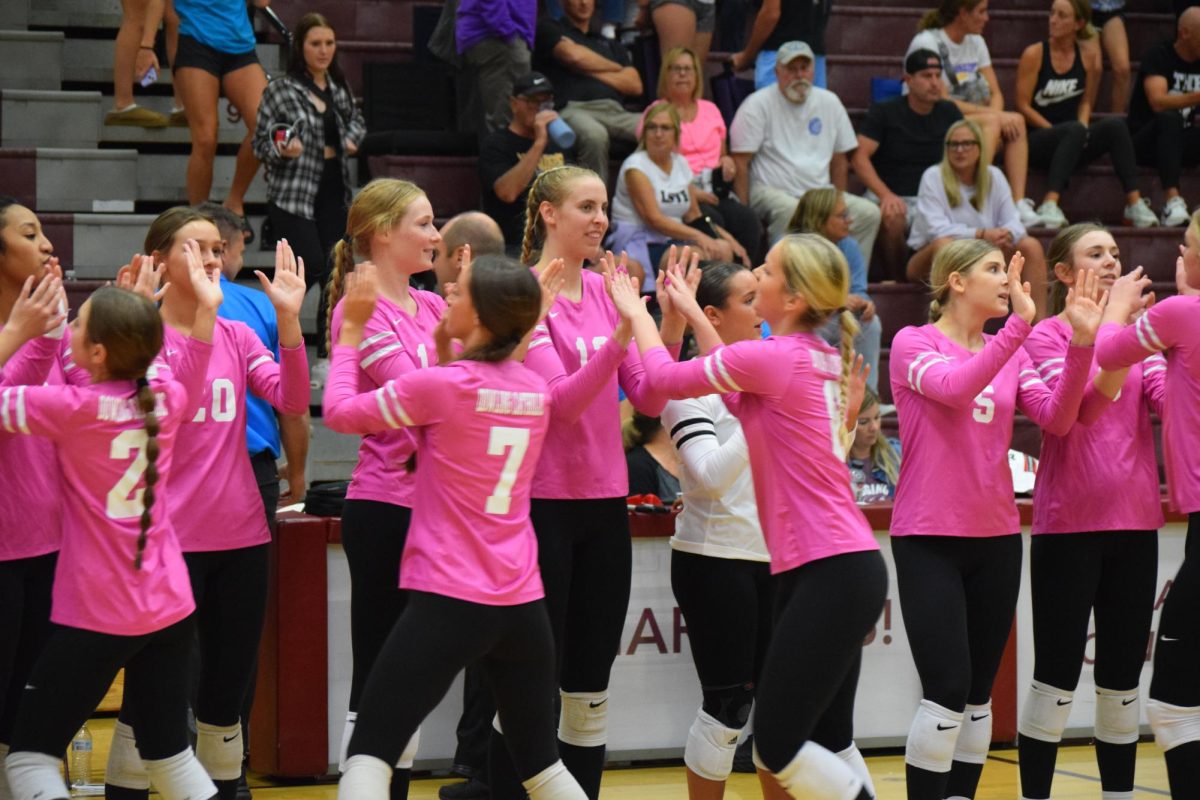 The team goes down the row for high fives after winning the match against Waukee.