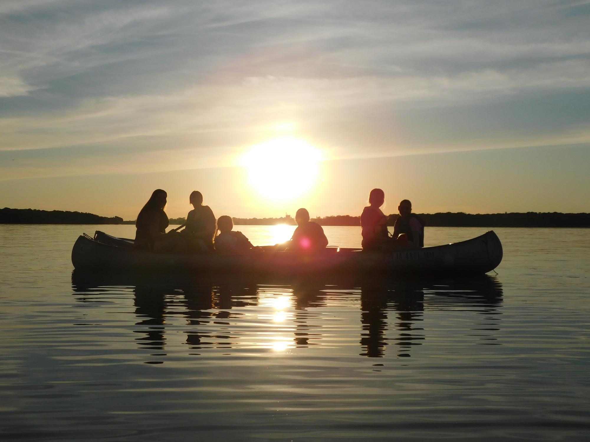 Two canoes out on the waters of Clear Lake filled with friends laughing and enjoying each other's company.