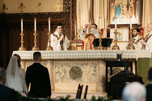 Father Flood celebrates communion at Coach V's wedding ceremony this past summer in Des Moines, Iowa.