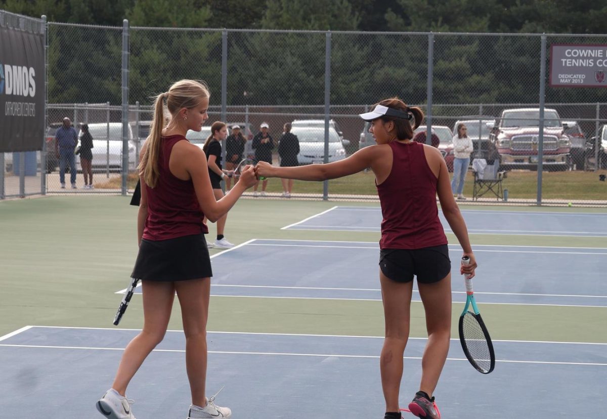 Ella Larson (12) and Lily Carfrae (12) fist bump after a successful point scored. 