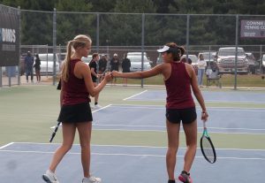 Ella Larson (12) and Lily Carfrae (12) fist bump after a successful point scored. 