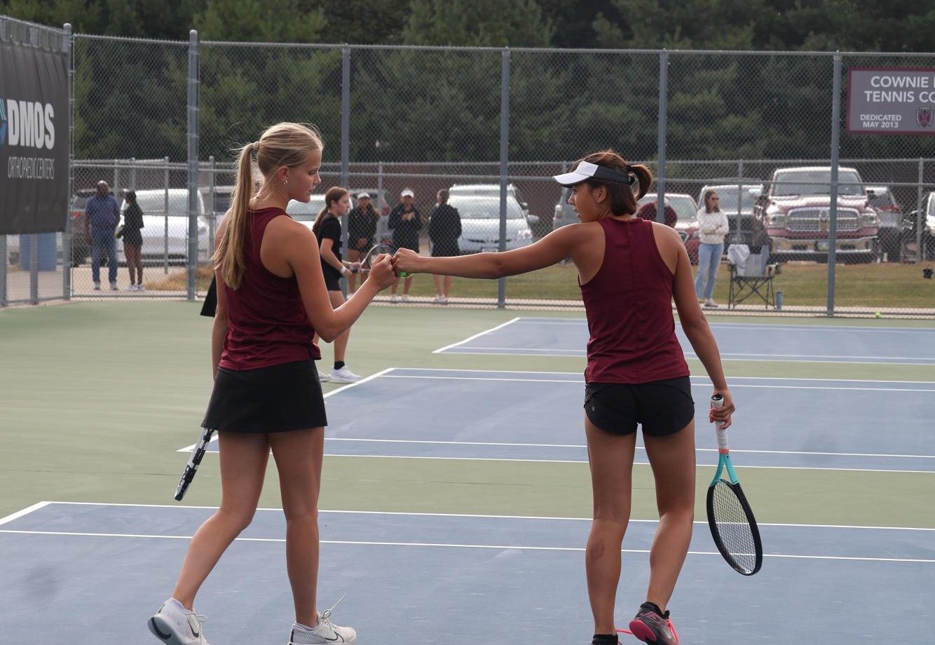 Ella Larson (12) and Lily Carfrae (12) fist bump after a successful point scored. 