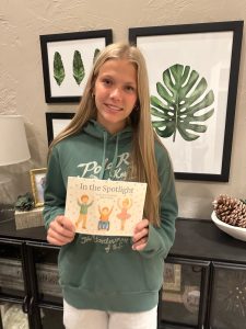 Ella Larson proudly holds her original children's story, "In the Spotlight". (E. Larson)