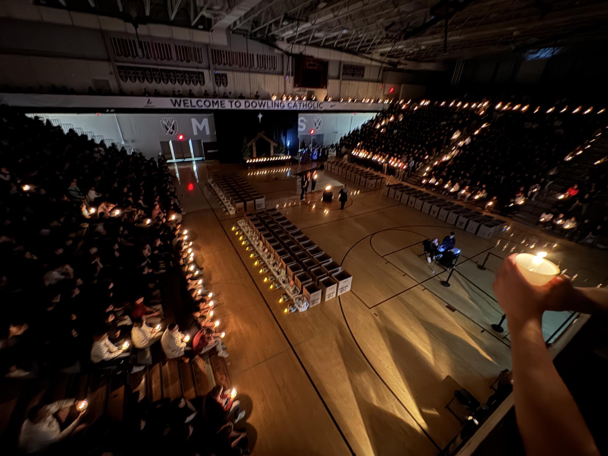The school holds candles to light up the gym. 