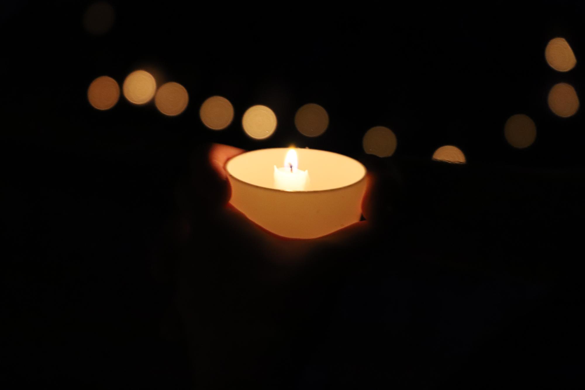 An up close shot of a candle with more flurrying in the background.