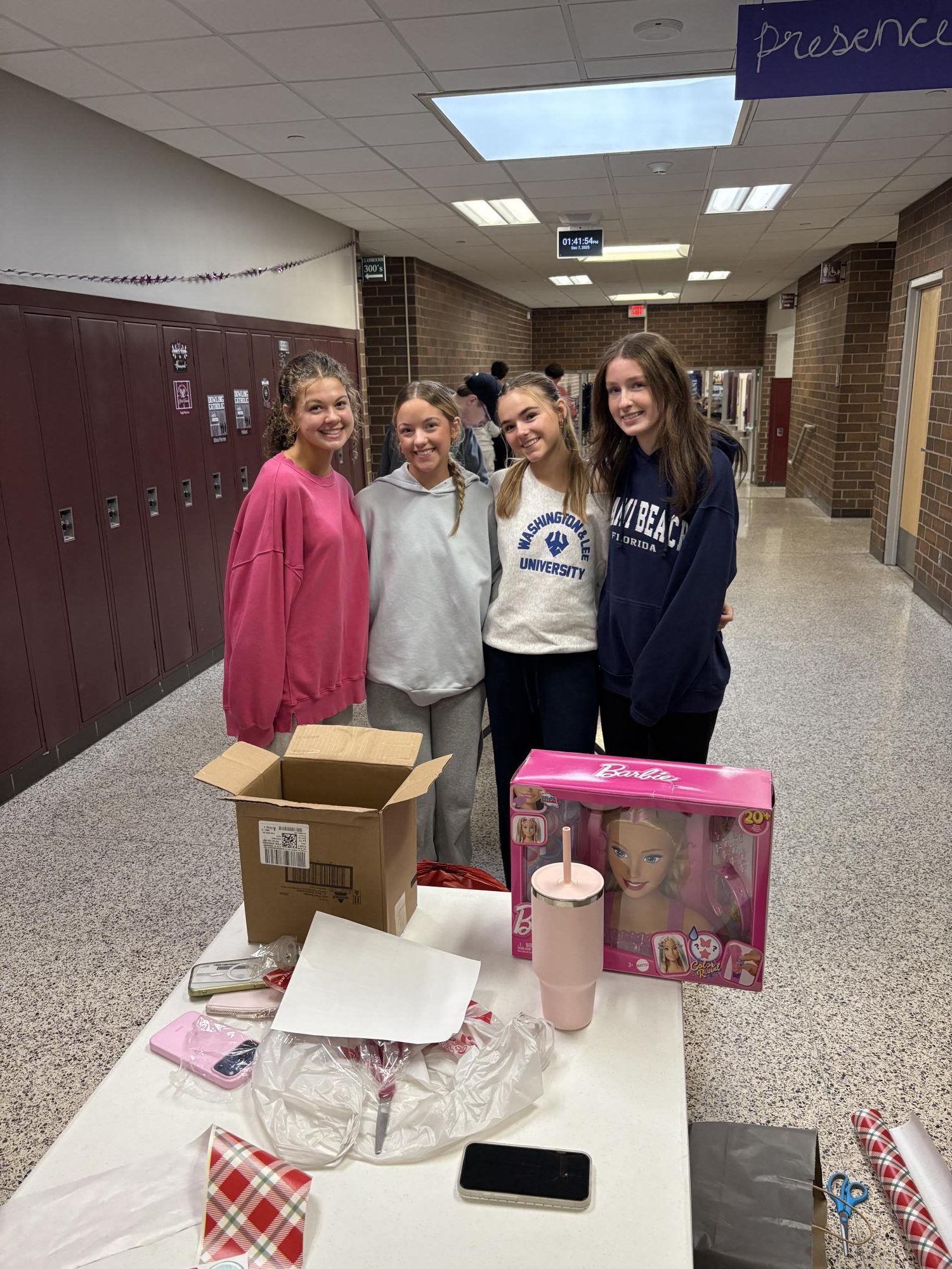 Anna Rauen and her group smile for a picture in-between wrapping presents. 