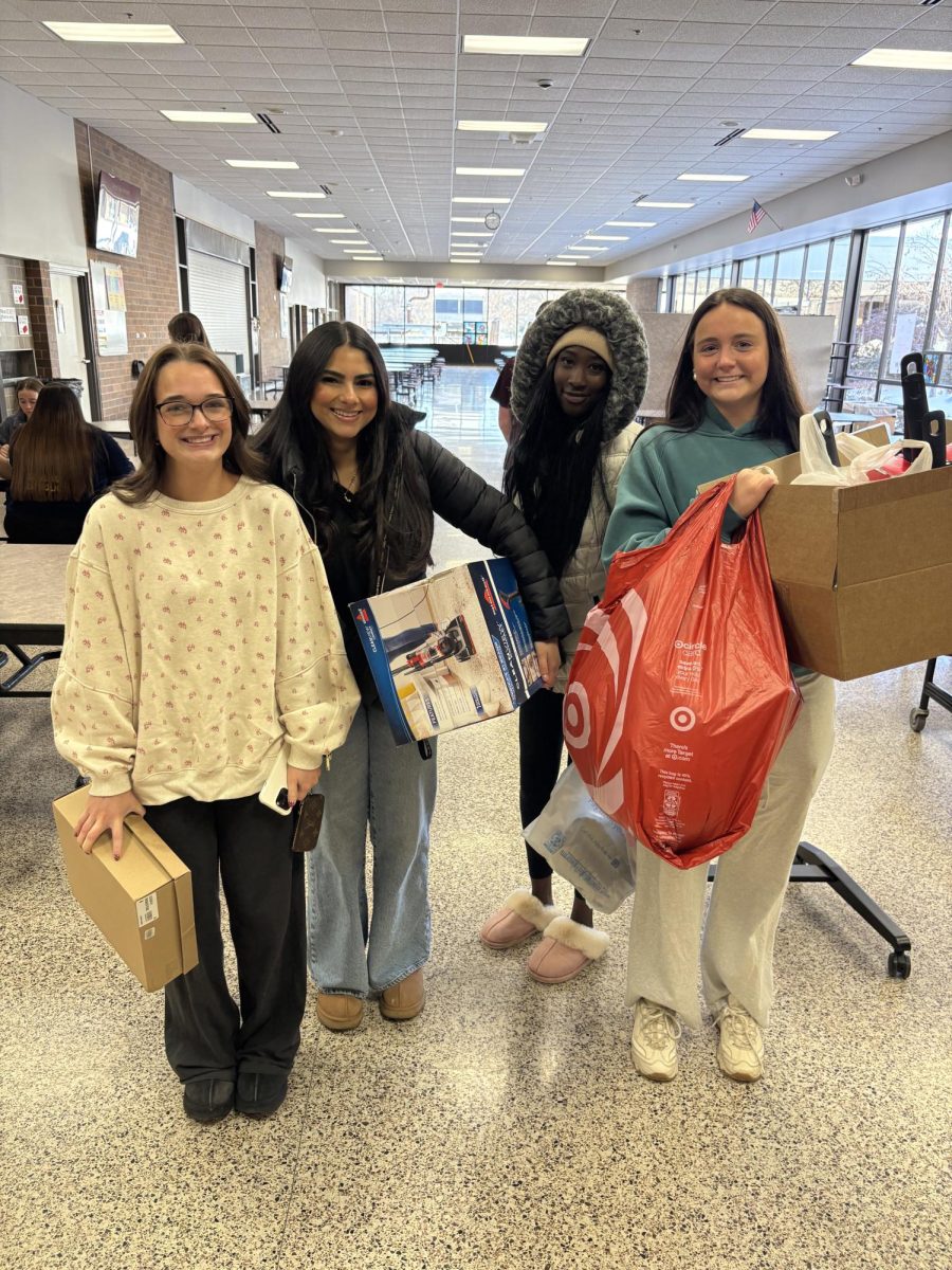 Tessa Potthoff and her group smile for a picture well holding their gifts. 