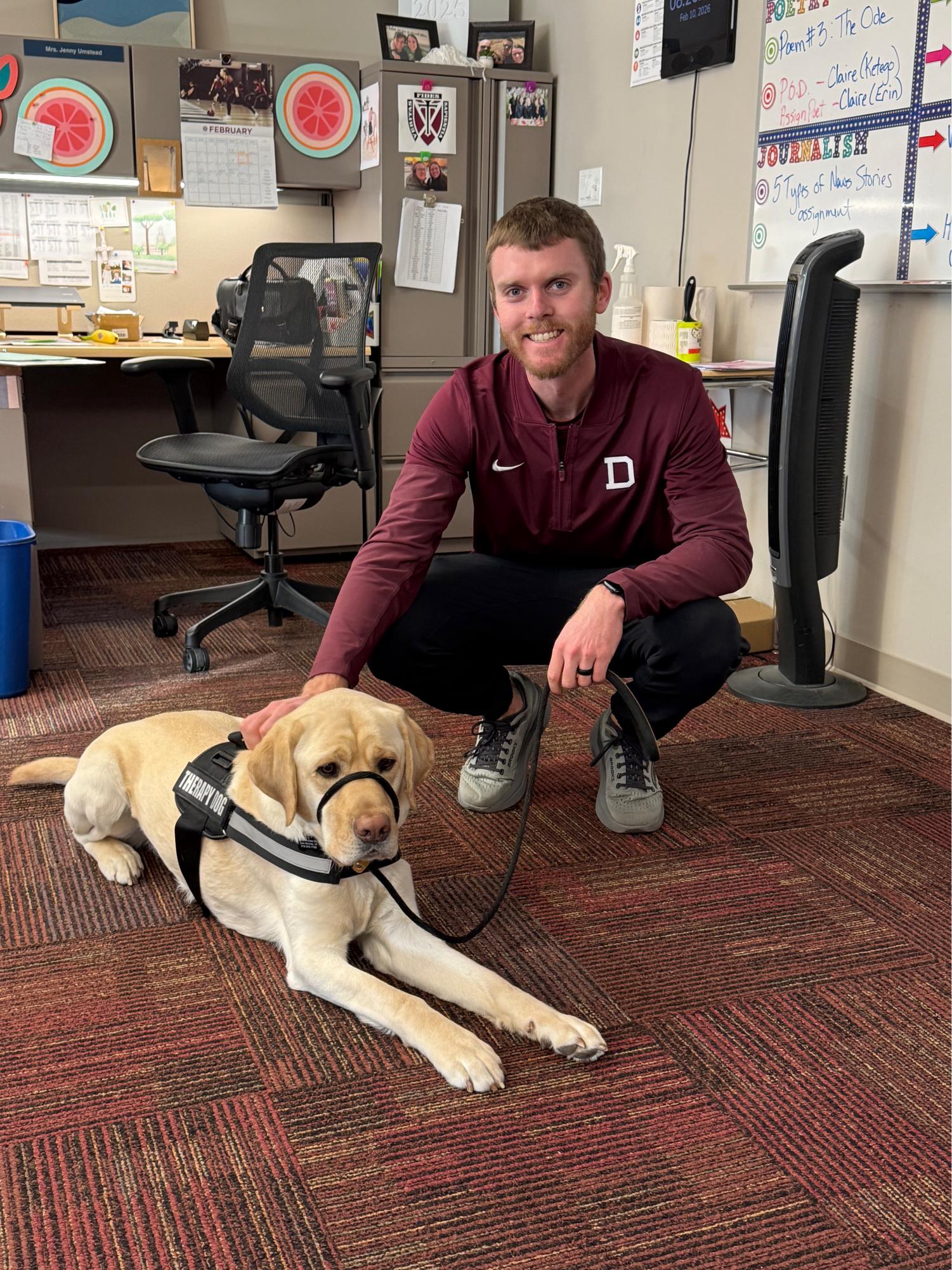 Mr. Nicholson and Sully, a trained therapy dog, smile for a picture.