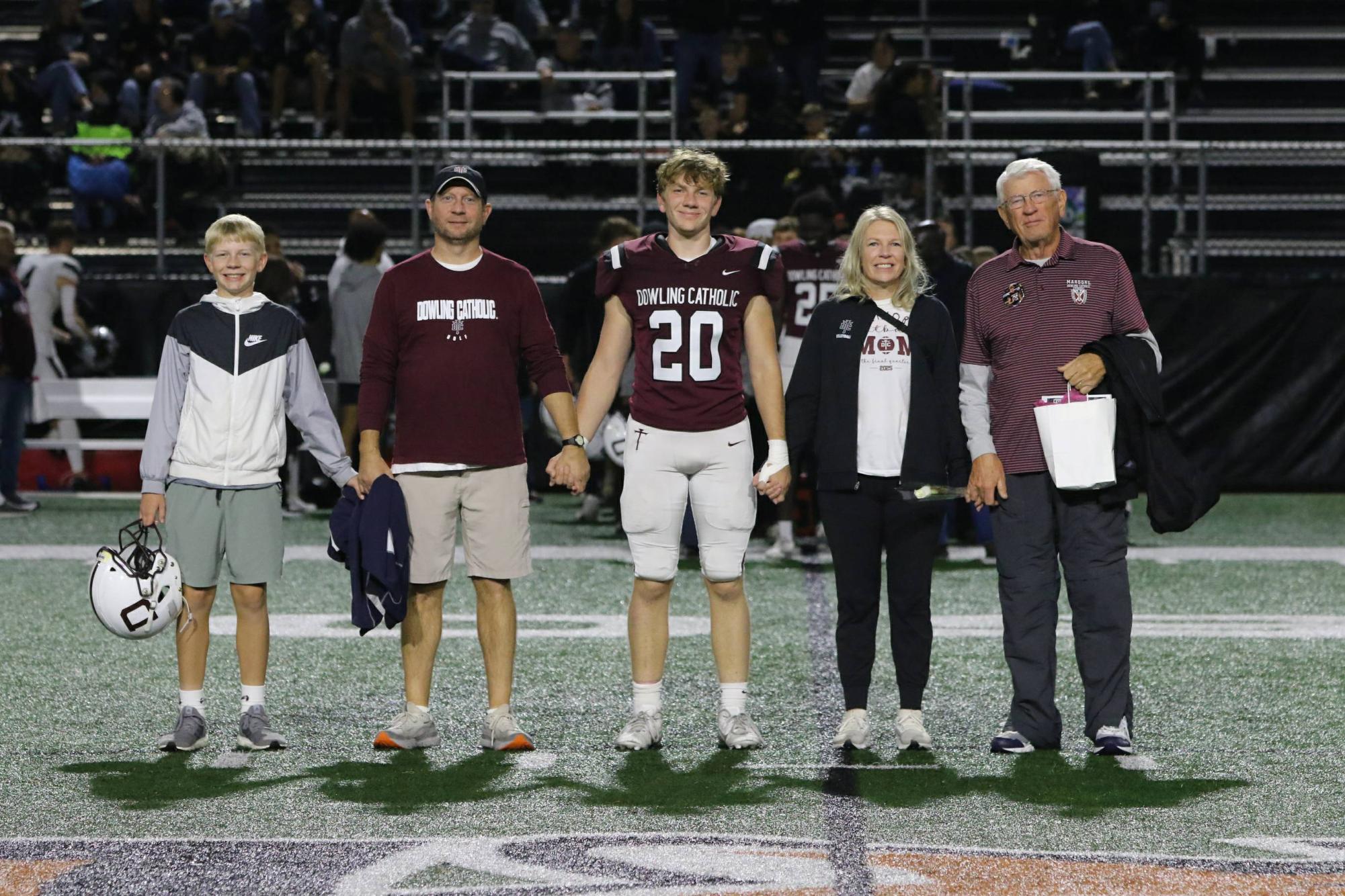 Tommy, Mr. Wiskus Matthew, Mrs. Wiskus, and her dad smile for a photo on Matthew's senior night. 