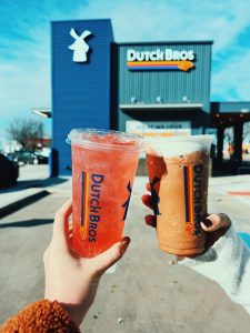 Logo of Dutch Bros accompanied by a variety of their drinks (Dallas Sites 101)